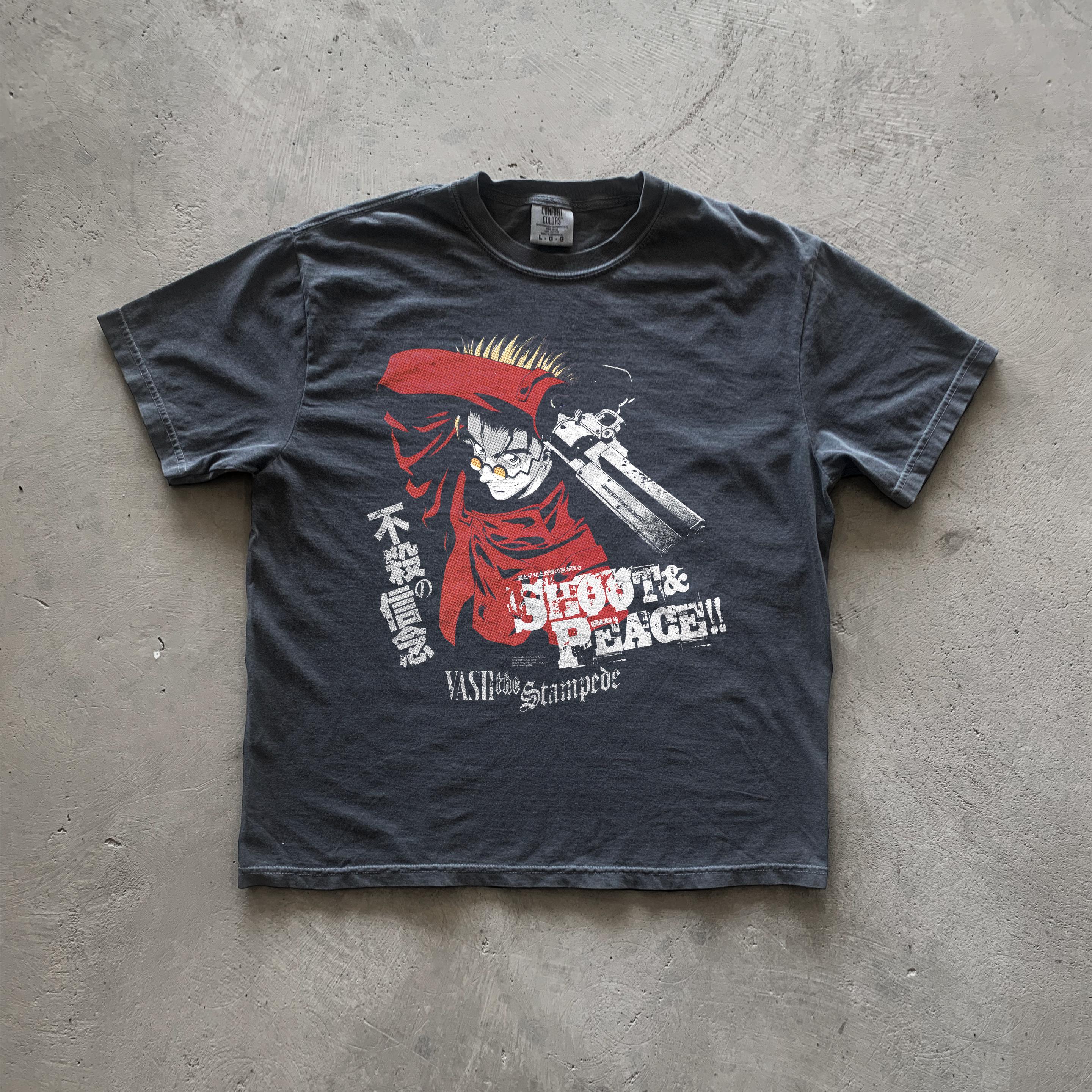 May include: A black t-shirt with a graphic print of a character from the anime Trigun. The character is holding a gun and has red hair. The text on the shirt reads 'Shoot & Peace!!' and 'Vash the Stampede'.